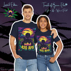 Links umarmt ein Mann eine Frau, die rechts steht, beide tragen identische dunkelblaue ADHD 420 Area T-Shirts, im Hintergrund ist die Silhouette einer Cannabisblüte zu sehen. Das Motiv auf den T-shirts zeigen eine friedliche Landschaft im warmen Licht des Sonnenuntergangs, in der die Hauptfigur – in Begleitung ihrer treuen schwarzen Katze – durch ein Cannabisfeld streift und die Ruhe der Natur genießt.