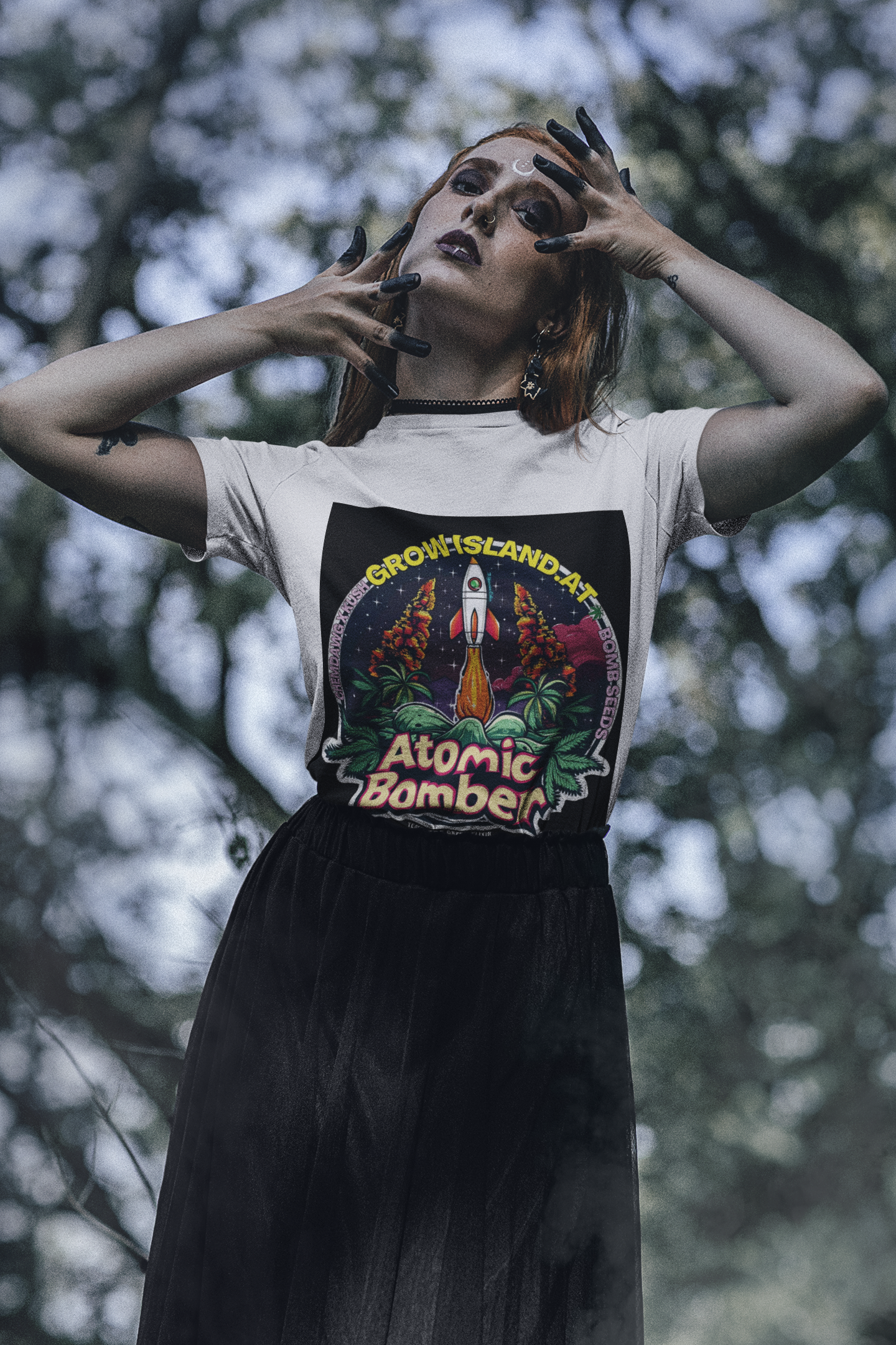 Eine im Dark-Stil als Hexe geschminkte Frau steht im Wald, trägt ein weißes Atomic Bomber T-Shirt und einen schwarzen Tüllrock.  Im Mittelpunkt steht eine startbereite Rakete zwischen Cannabisblättern, die vor einem brennenden Himmel und in kosmischer Atmosphäre zum Leben erwacht. 