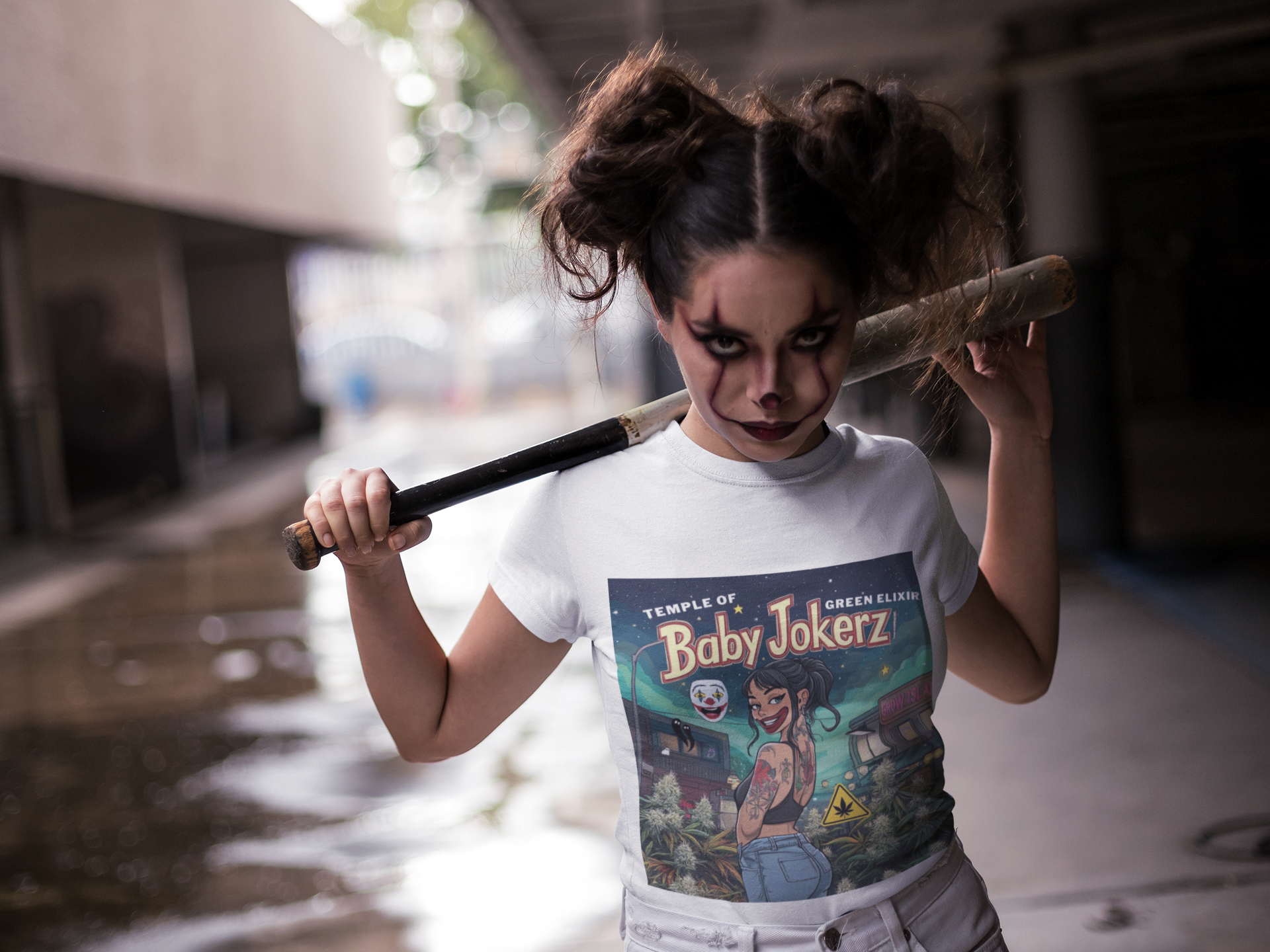 Ein Mädchen, als Clown geschminkt, trägt ein weißes Baby Jokez T-Shirt und hat einen Baseballschläger lässig über die Schulter gelegt, auf der Straße. Auf dem T-shirt  neben dem Neonlicht von Grow Island, dreht sich das Baby-Jokerz-Girl mit einem selbstbewussten Lächeln zu dir um – als hätte sie gerade eine geheime Botschaft hinterlassen. Im Hintergrund vermischen sich Sterne, der Duft von Gras und das Gefühl von Freiheit, Vorne viele Cannabis Pflanzen und Buds
