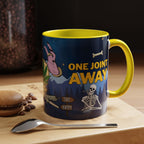 Eine zweifarbige Heaven is just one joint away Keramiktasse, Temple of Green Elixir mit gelbem Henkel und Innenraum, die auf einem Holztisch neben einem Macaron, Kaffeebohnen und einem Löffel steht. Der umlaufende Cartoon-Druck zeigt eine humorvolle nächtliche Szene mit einem rauchenden Skelett, einem Wegweiser ('Sad'/'Happy') und dem Slogan 'ONE JOINT AWAY', was der gemütlichen Kaffeepause eine ironische Note verleiht.﻿