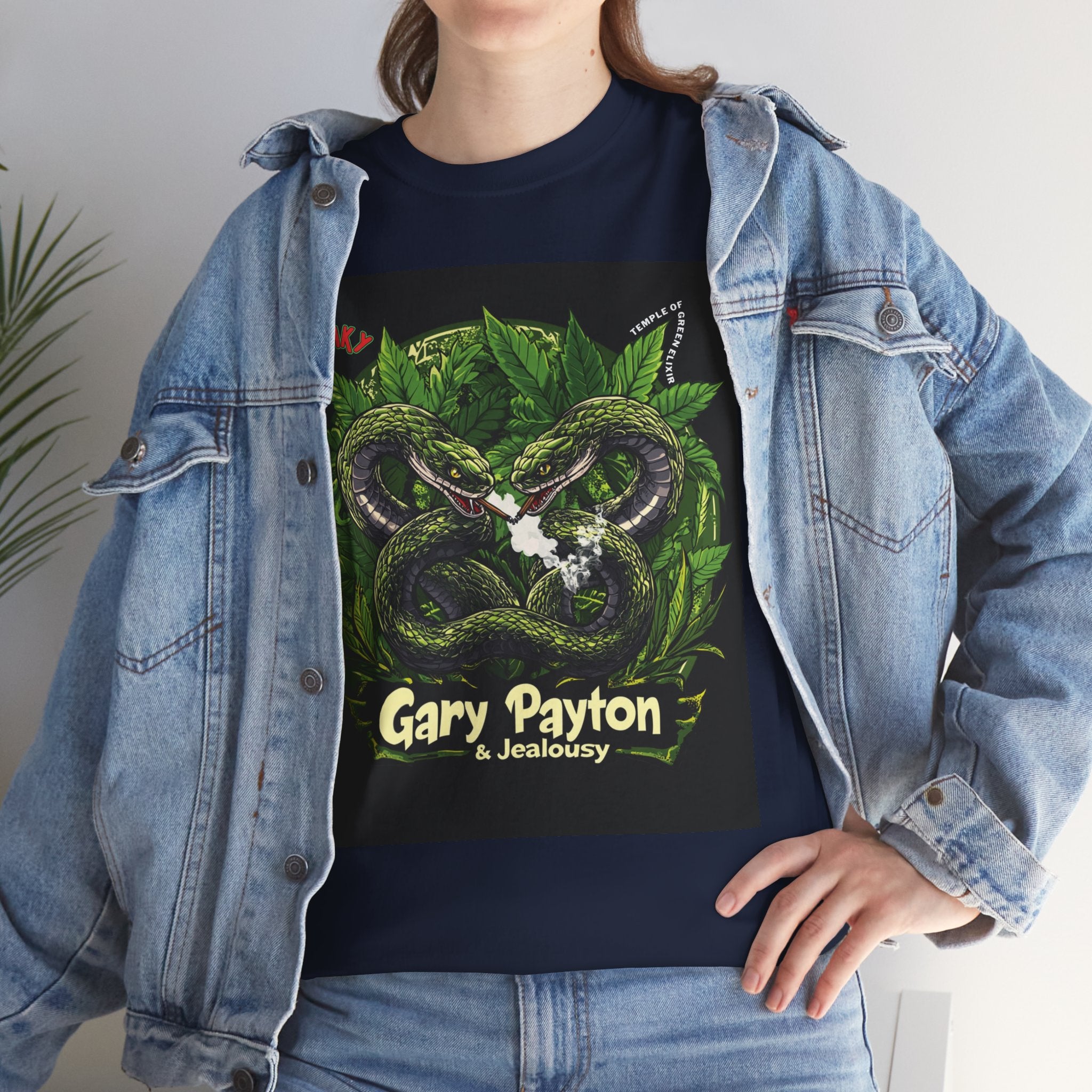 Model steht im Jeans Jacke und Gary Payton & Jealousy dunkelblaues T-shirt, mit Zwei mächtige, grün beschuppte Schlangen winden sich umeinander, in ihren Augen funkeln uralte Weisheit und spielerische Herausforderung.  Im Hintergrund rahmen üppige Cannabisblätter die Szene ein und verleihen der Komposition Stärke, Tiefe und eine dunkle Eleganz. 