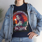 Model steht im Jeans Jacke und dunkelblaues High Society T-shirt mit dem Design: Am Horizont, in den Rot- und Orangetönen des Sonnenuntergangs, nähert sich ein altes Segelschiff, während am Ufer eine Meeres-Sirene mit langem, feuerrotem Haar und spitzen Ohren steht – in ihrem Blick liegen alle Geheimnisse des Meeres. Neben ihrem Arm symbolisieren Cannabisblätter und feiner Rauch die Genüsse des Lebens und das Gefühl, zu den oberen Kreisen zu gehören. 