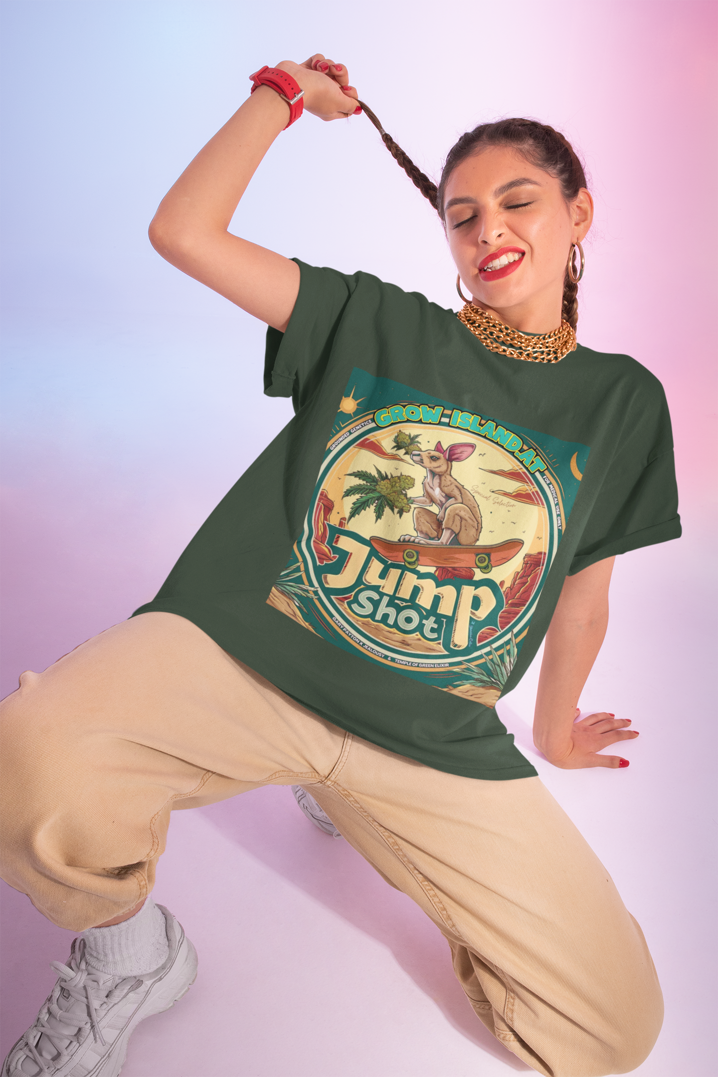 Eine junge Frau hockt halb und zwinkert vor einem rosa Hintergrund, trägt ein grünes Jump shot Vintage T-Shirt und spielt mit ihrem Haar.  Im Mittelpunkt der Grafik steht ein skateboardfahrendes Känguru, das stolz einen frischen, harzreichen Cannabiszweig in der Pfote hält. Die roten Felsen im Hintergrund und die warmen Töne des Wüstensonnenuntergangs rufen das Gefühl von Freiheit und den wilden Westen wach. 
