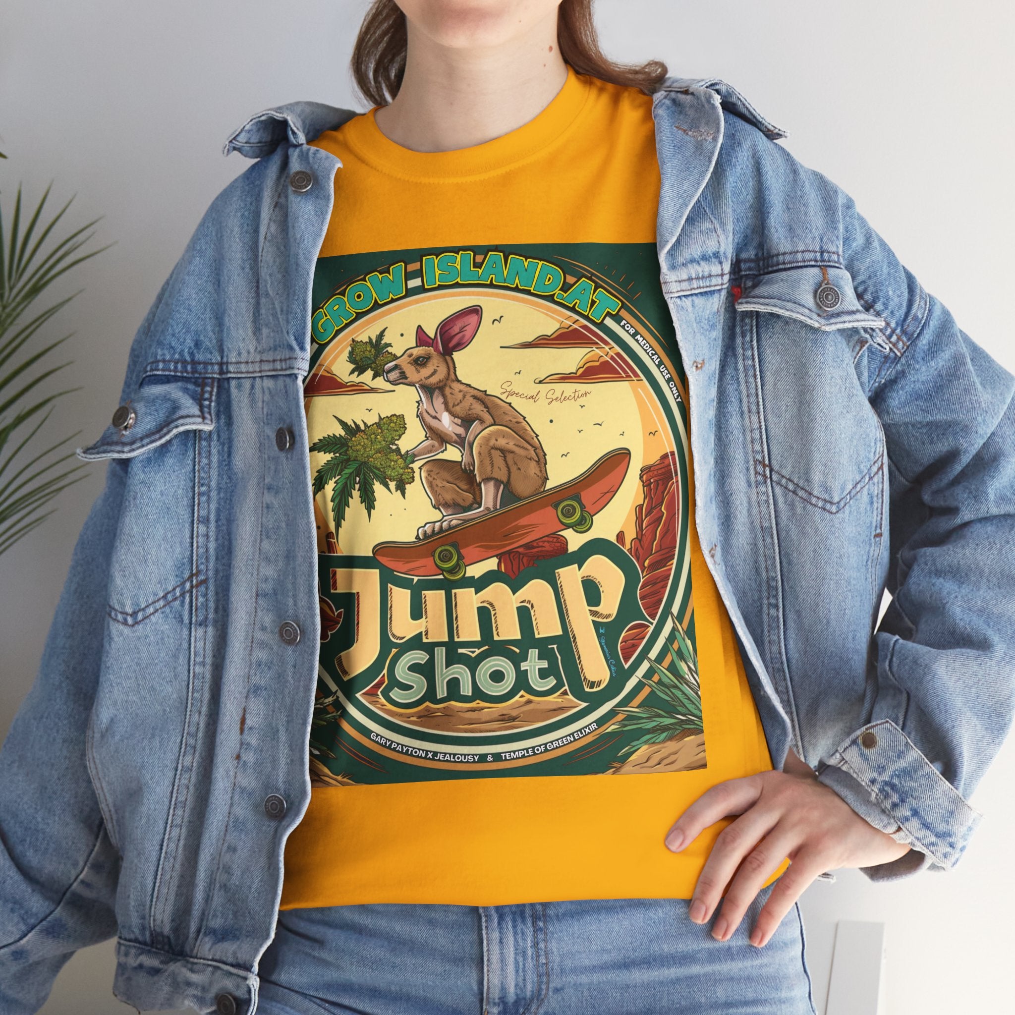 Model steht im Jeans Jacke und Jump shot Vintage gelbes T-shirt. Im Mittelpunkt der Grafik steht ein skateboardfahrendes Känguru, das stolz einen frischen, harzreichen Cannabiszweig in der Pfote hält. Die roten Felsen im Hintergrund und die warmen Töne des Wüstensonnenuntergangs rufen das Gefühl von Freiheit und den wilden Westen wach. 