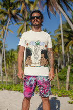 Mann steht am Strand vor Palmen, trägt ein weißes T-Shirt mit bunter Grafik von zwei Personen, die miteinander rauchen, Rauch in Herzform, Cannabisblatt und englischem Text „La Macdonia”, „The Souls Type Smoke”, „Temple of Green Elixir”, dazu bunte Shorts mit Blattmuster.