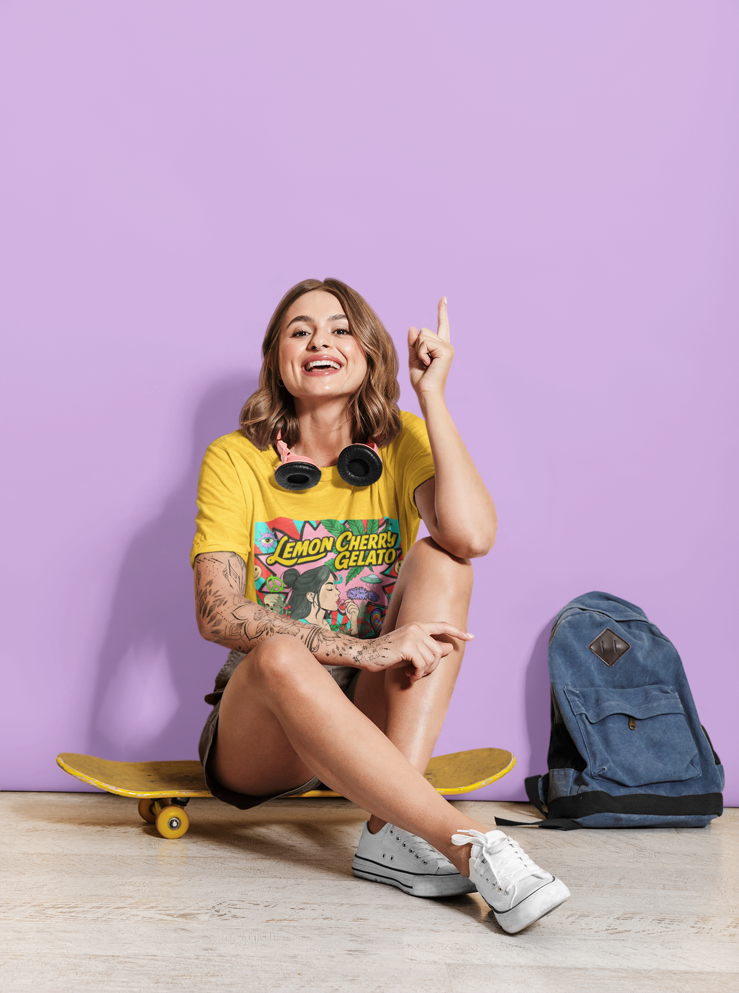 tatowierte Junge Frau sitzt auf gelbe Skatebord im gelbe Lemon cherry Gelato T-shirt mit Lila hintergrund
