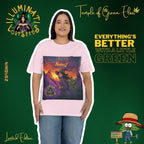 Dame steht in hellrosa T-Shirt mit NimbusZ-Motiv vor grünem Hintergrund, umgeben von Schriftzügen wie ‚Illuminati Lost Seeds‘ und ‚Temple of Green Elixir‘ sowie dem Slogan ‚Everything’s better with a little green‘ und Limited Edition Logos. Auf dem T-shirt Hexe im violetten Zauberergewand mit Hut steht mit einem Stab in der Hand in einer Landschaft bei Sonnenuntergang, zwischen grünen Cannabis-Pflanzen. Oben der Schriftzug ‚NimbusZ‘ und ‚Temple of Green Elixir Limited Edition‘