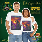 Junges Paar umarmt sich, der Mann steht links, die Frau rechts, beide tragen weiße NimbusZ T-Shirts, mit Motiv: Hexe im violetten Zauberergewand mit Hut steht mit einem Stab in der Hand in einer Landschaft bei Sonnenuntergang, zwischen grünen Cannabis-Pflanzen. Oben der Schriftzug ‚NimbusZ‘ und ‚Temple of Green Elixir Limited Edition‘, unten das Logo ‚Illuminati Lost Seeds‘.