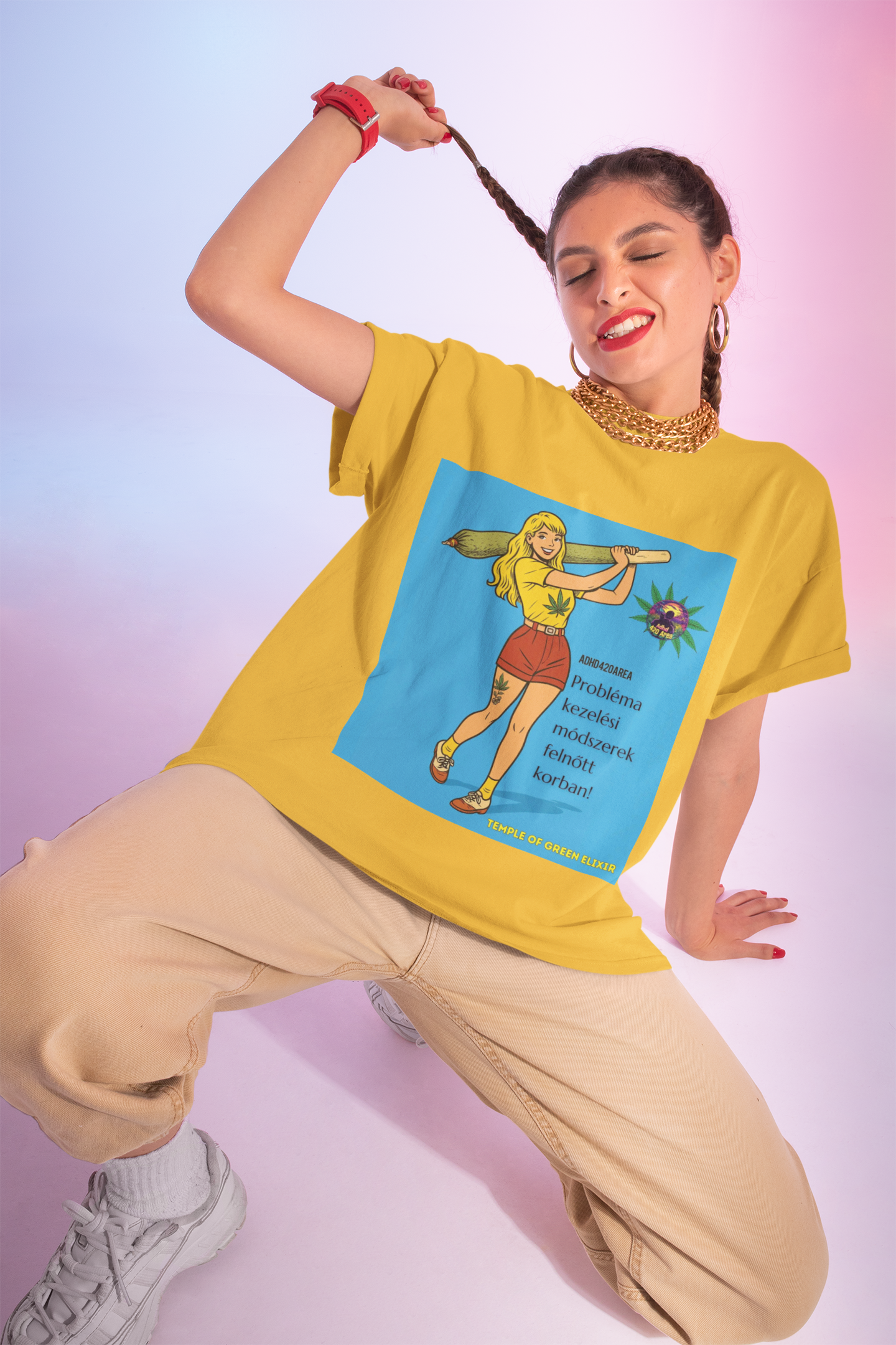 Junge Frau in gelbem T-Shirt mit bunter Grafik einer Frau, die einen großen grünen Joint hält, Hanfblatt-Design und dem deutschen Text „ADHD42QAREA Problembehandlungsmethoden im Erwachsenenalter! Temple of Green Elixir“, posiert modisch vor einem pink-blauen Hintergrund.