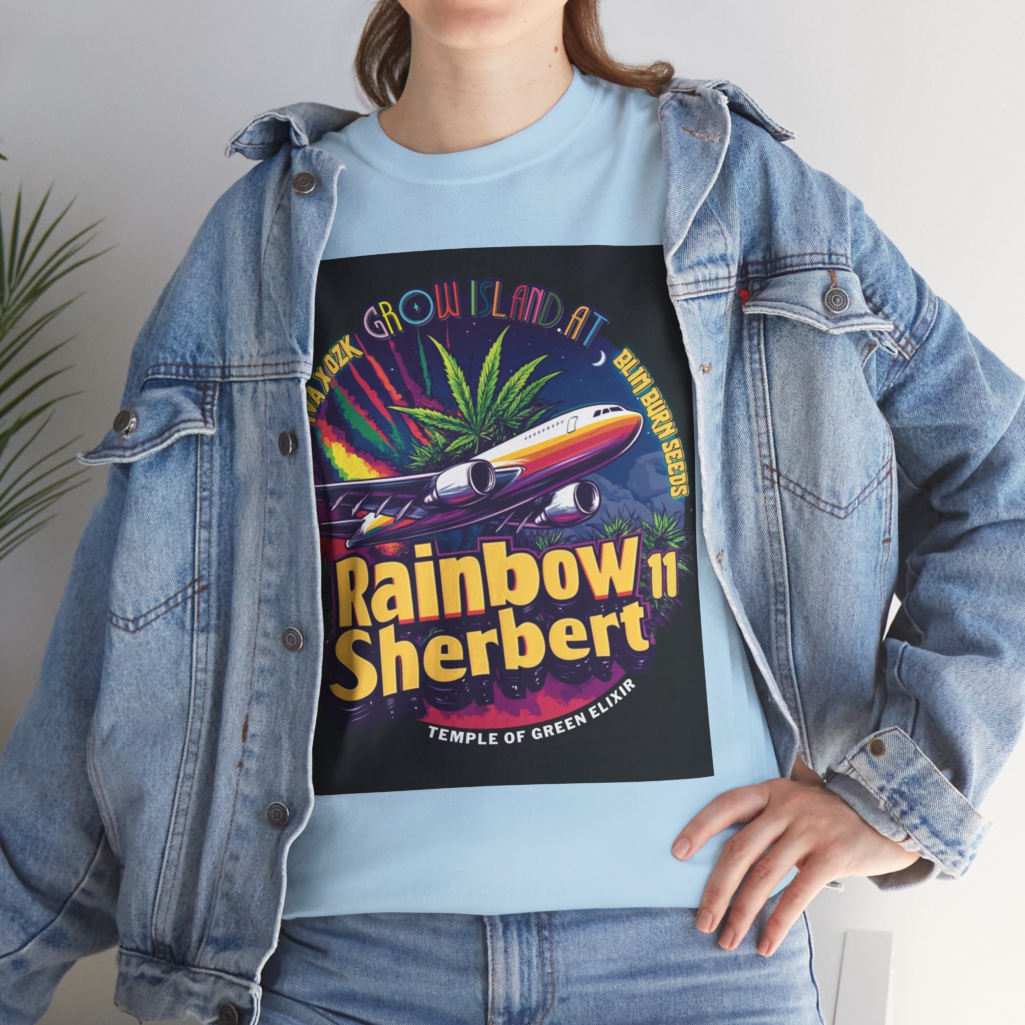 Model trägt Jeans Jacke und Rainbow Sherbert 11 hellblaues T-Shirt. Im Mittelpunkt des Designs steht  farbenfrohes Strahlflugzeug, das den Himmel über Cannabispflanzen durchquert, während es eine Regenbogenspur hinterlässt.
