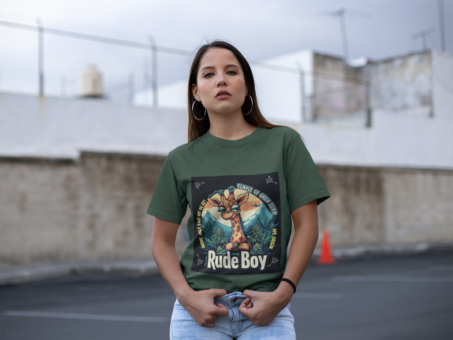 Model steht auf der Straße in einem Rude boy forest green T-shirt, auf dem T-shirt Giraffe mit cannabis buds und Gebirge rund herum.
