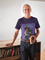 Ein eleganter, älterer Herr mit weißem Haar lehnt lässig an einem Bücherregal und hält ein Buch in der Hand. Er trägt das dunkelviolette T-Shirt mit dem ironischen 'Igaz Szerelem'-Aufdruck und beweist mit seinem Lächeln, dass Humor und ein guter Geschmack kein Alter kennen.﻿