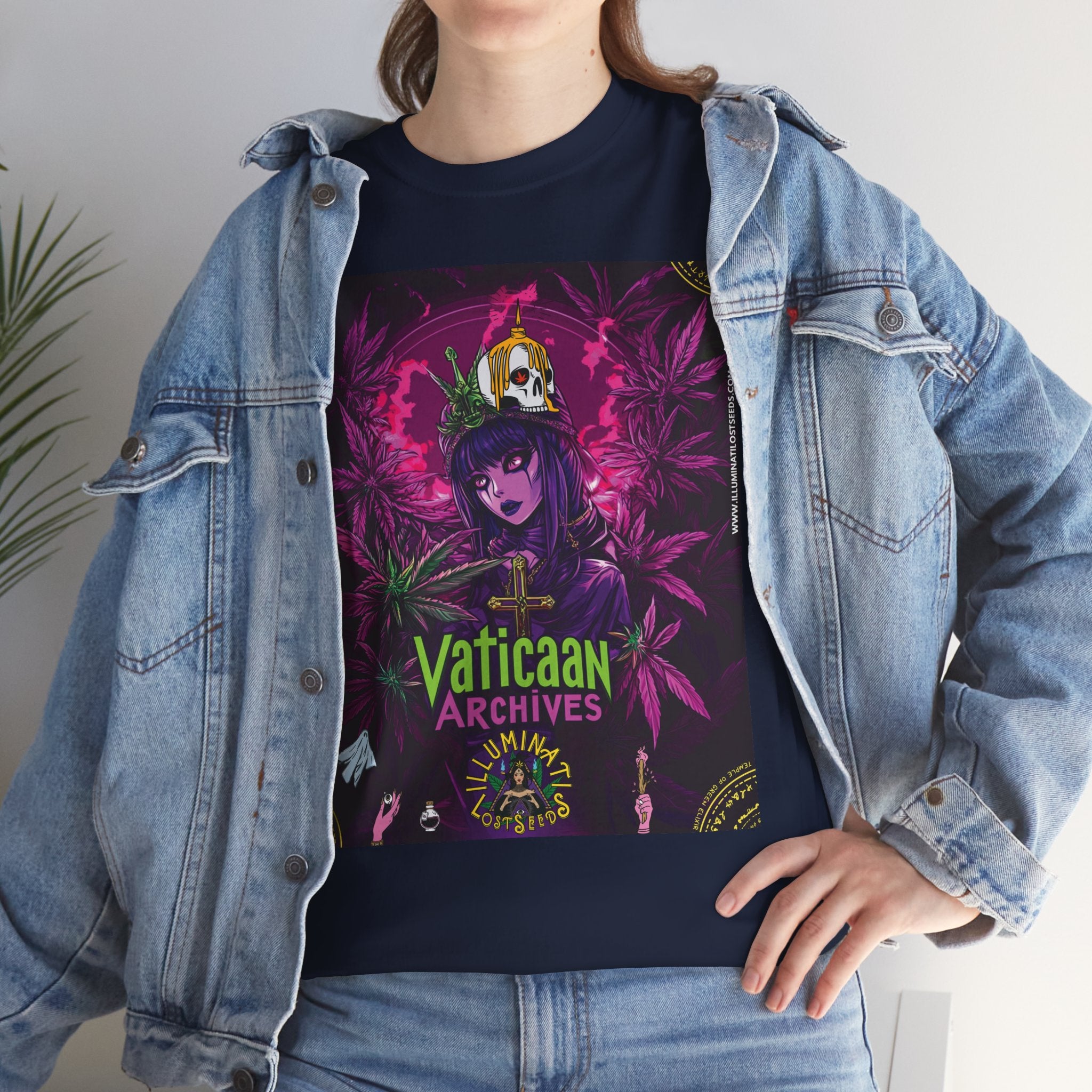 Model trägt Jeansjacke und Vaticaan Archives dunkelblaues T-shirt mit Motiv: gotische Figur, umgeben von lilafarbenen und grünen Cannabisblättern. Auf ihrem Kopf thront eine provokative Krone mit Kreuzmotiv.  Im unteren Bereich steht der grüne Schriftzug ‚Vaticaan Archives‘ und das Illuminati Lost Seeds Logo, dekoriert mit kleinen Symbolen.