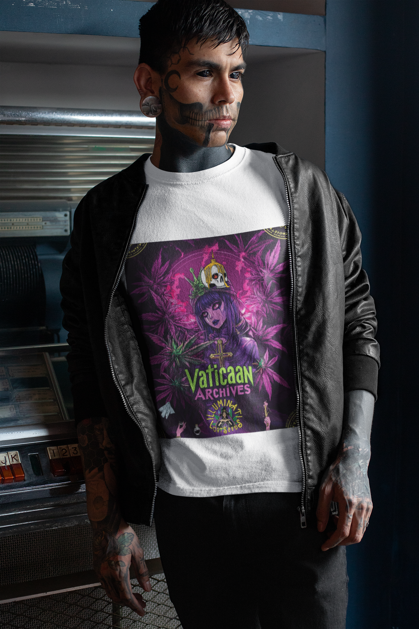 Tattooierter Mann steht in weißem T-Shirt mit Vaticaan Archives-Motiv und schwarzer Lederjacke vor einem Automaten. Auf dem Tshirt steht eine  gotische Figur, umgeben von lilafarbenen und grünen Cannabisblättern. Auf ihrem Kopf thront eine provokative Krone mit Kreuzmotiv.  Im unteren Bereich steht der grüne Schriftzug ‚Vaticaan Archives‘ und das Illuminati Lost Seeds Logo, dekoriert mit kleinen Symbolen.