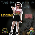 Junge Frau mit rosa Haaren und Hut steht in Shorts und rosa T-Shirt mit Wasen Brezer-Motiv, zeigt das Peace-Zeichen. Im Hintergrund verschiedene Schriftzüge wie ‚Temple of Green Elixir‘, ‚Stay High, Stay Focused‘ und animierte Logos. AUf dem T-shirt Frau im Dirndl hält ein Bierglas mit ‚Wasen Brezer‘-Aufschrift und eine Brezel, umgeben von grünen Pflanzen vor Sonnenuntergang. Oben links das Logo ‚Illuminati Lost Seeds‘, unten der große Schriftzug ‚Wasen Brezer‘ und die Webseite.